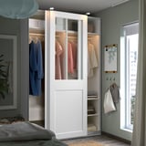 Georganiseerde slaapkamer met witte PAX kledingkast, groene muren en gezellig bed.