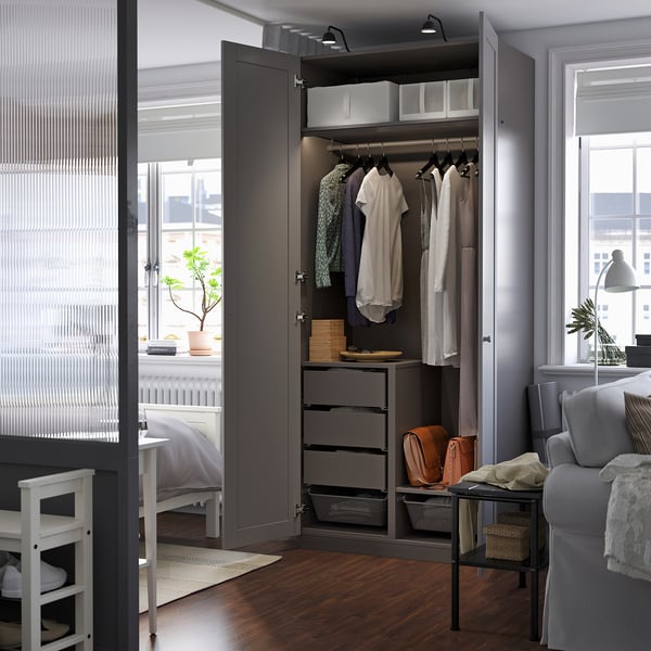 Grote open kledingkast met kleding en lades in een kamer, met opslag en organisatie.