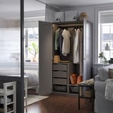 Moderne kledingkast met open deur die kleerhangers en opberglades onthult, gelegen in een gezellige kamer met een raam.