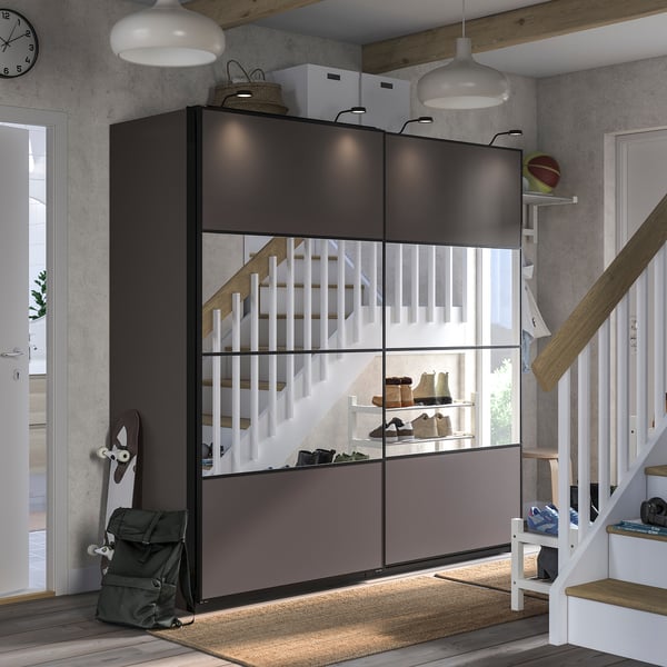 Moderne entree met zwarte PAX opslag, witte trap, grijs vloerkleed.