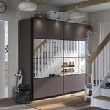 Moderne entree met zwarte PAX opslag, witte trap, grijs vloerkleed.