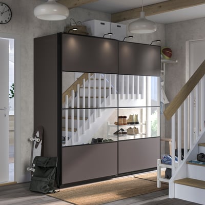 Moderne entree met zwarte PAX opslag, witte trap, grijs vloerkleed.