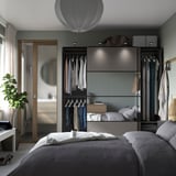 Moderne slaapkamer, een grijskleurige PAX kledingkast met schuifdeuren en geïntegreerde verlichting, biedt veel opbergruimte en een strak design.