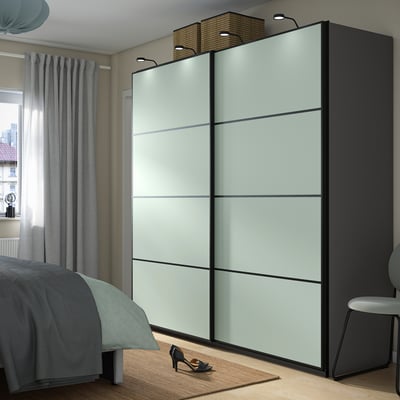 Moderne slaapkamer met strakke, spacer lichtblauwe PAX kledingkast, spiegeldeuren en ingebouwde verlichting.