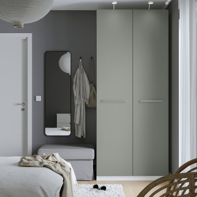 Moderne slaapkamer met groene PAX kledingkast, spiegel en hanglamp.