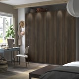 Moderne slaapkamer met grote donkerbruine PAX kledingkast, raam en kantoor aan huis.