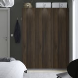 Houten PAX kledingkast, donkere afwerking, drie deuren, naast het bed, bekroond met witte dozen en hoed. Blauw item en lamp aan de muur. Hoog, verticaal brandpunt.
