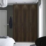 Moderne slaapkamer met grote donkere PAX kledingkast. Wit bed, blauwe jas bij deur.