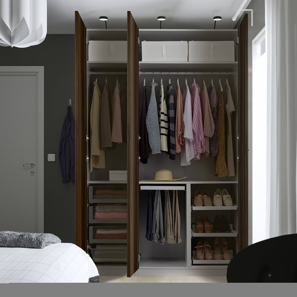 Open kledingkast toont kleding, schoenen en accessoires op hangers, planken en lades.