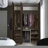 Open kledingkast toont kleding, schoenen en accessoires op hangers, planken en lades.