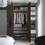 Een moderne, georganiseerde kledingkast met open deuren met hangers met kleding, planken en opbergdozen.