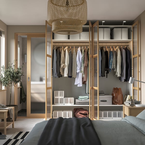 Moderne kledingkast met hangende kleding, planken en een stijlvolle hanglamp. Onderdeel van een georganiseerde slaapkamersuite.