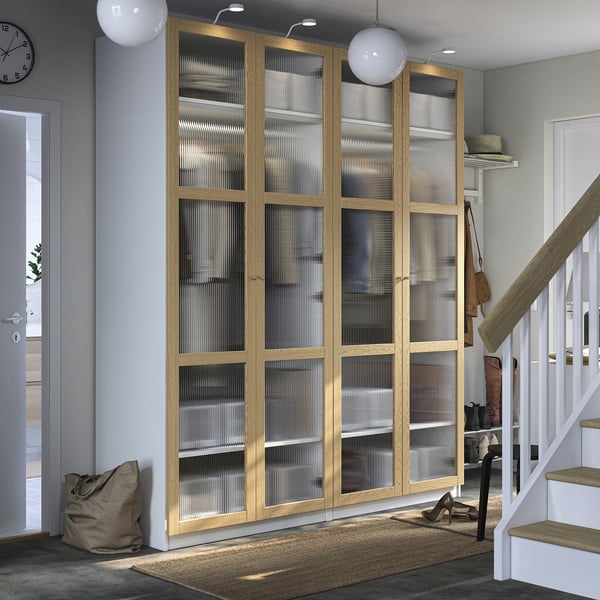 Houten PAX kledingkast met matglas in grijze kamer. Nabij trappen, met vloerkleed en decor.
