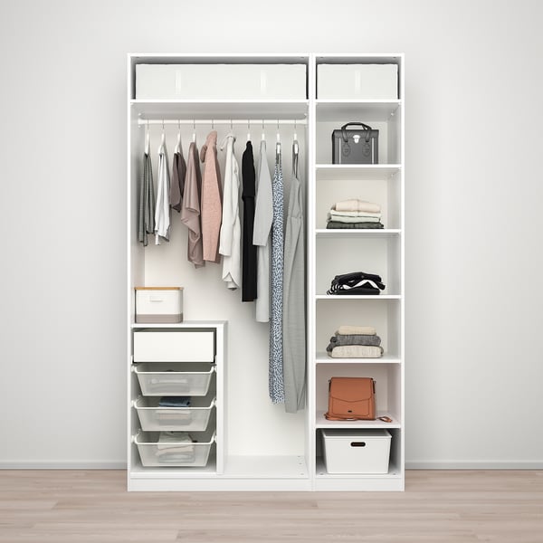 Een witte kledingkast PAX met hangende kleding, opgevouwen items, manden en accessoires netjes georganiseerd.