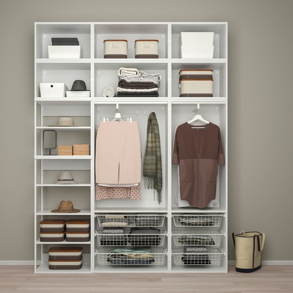 Wit PLATSA opbergsysteem met legplanken en lades. Er zitten kleding, hoeden en bakken in, netjes georganiseerd.