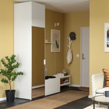 Moderne entree met hoge witte PLATSA unit. Gespiegelde deur, mosterdkleurige muur, minimalistisch design.