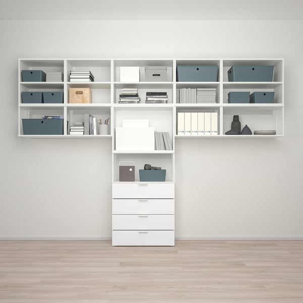 Moderne opbergset: planken en lades met opbergdozen tegen lichte muur, houten vloer.