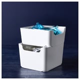 Stapel witte gerecycleerde plastic dozen met blauwe flessen en potten.