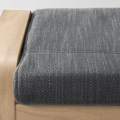 Afbeelding moderne voetenbank met getextureerd grijs kussen en licht houten frame.