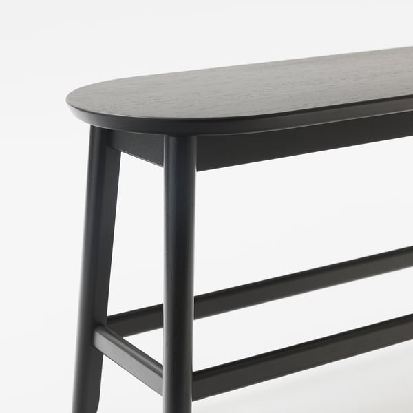 Zwarte moderne bank met strakke, gebogen randen en stevige houten poten in minimalistisch design.