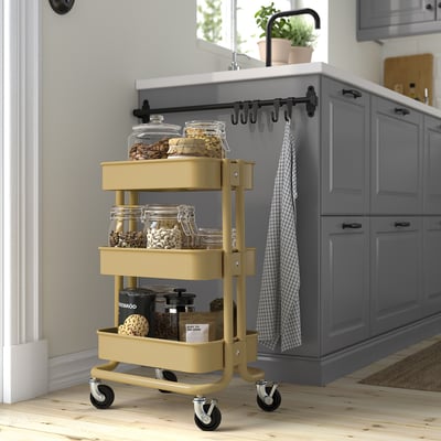 Gele RÅSKOG opbergwagen met potten in moderne keuken, past onder toonbanken.