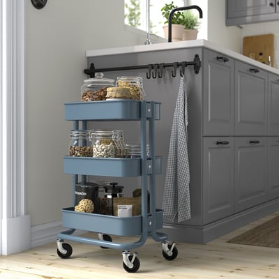 Blauwe ikea RÅSKOG trolley in de keuken, met potten, past onder de toonbank.