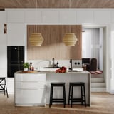Moderne keuken met witte hoogglans kasten, houten accenten, zwarte krukken en unieke hanglampen.