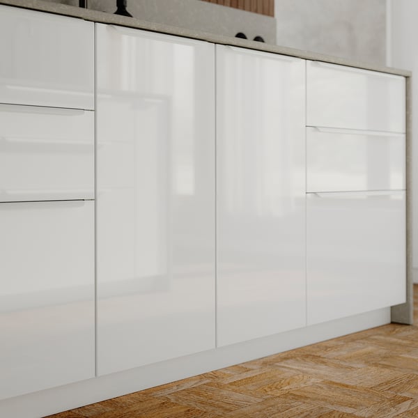 Moderne witte keukenkasten met hoogglans afwerking, rechte lijnen en strakke handgrepen.