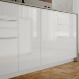Moderne witte keukenkasten met hoogglans afwerking, rechte lijnen en strakke handgrepen.