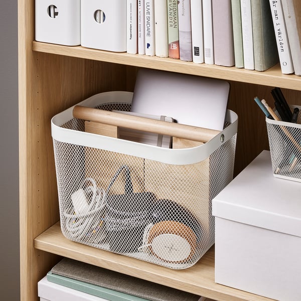 Mesh opbergmand op plank, met laptop en houten voorwerpen, georganiseerd met verdeler, ideaal voor werk of thuis.