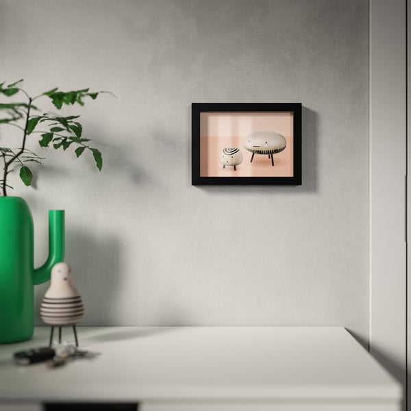 Ingelijste foto op grijze muur boven witte tafel, verstelbare & ph-neutrale montage.
