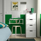 Witgroene slaapkamer met RUNDOXEL spiegel, ijdelheid, veelkleurig kussen, groen vloerkleed en hoge lade.
