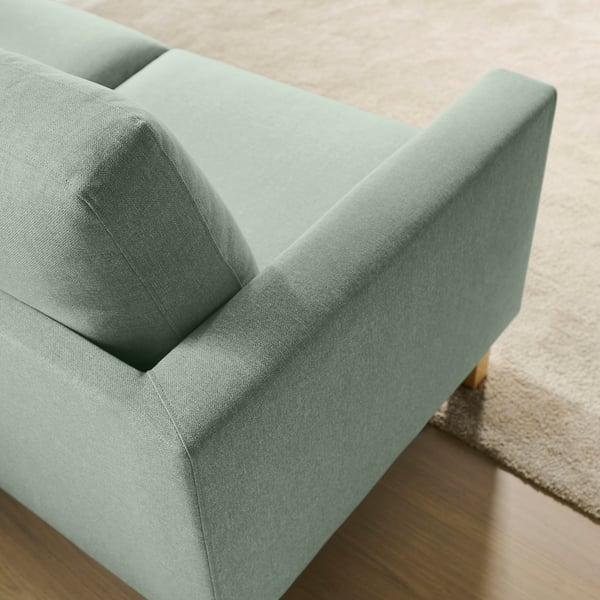 Moderne groene bank met hoogwaardige stof en strak ontwerp, die kussens en stevig frame accentueren.