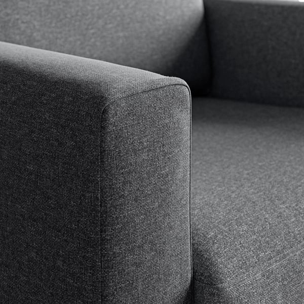 Moderne stoffen fauteuil van dichtbij, met hoogwaardige, zachte, getextureerde bekleding en robuuste constructie.