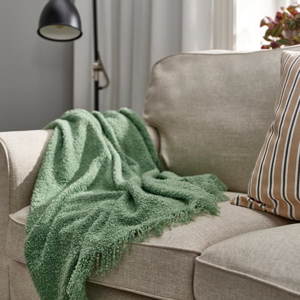 Groene SANDBRODD gerecycled polyester plaid op de bank.