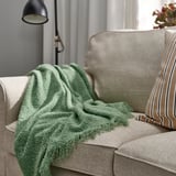 Groene SANDBRODD gerecycled polyester plaid op de bank.