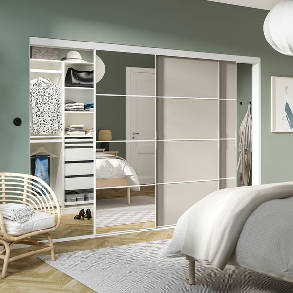 Witte SKYTTA kledingkast met spiegeldeuren weerspiegelt slaapkamer, huisvesting kleding met moderne elegantie.