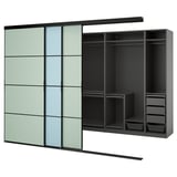 SKYTTA kast met zwart en groen getinte schuifdeuren, onthullende georganiseerde planken en laden, minimalistische opslag.