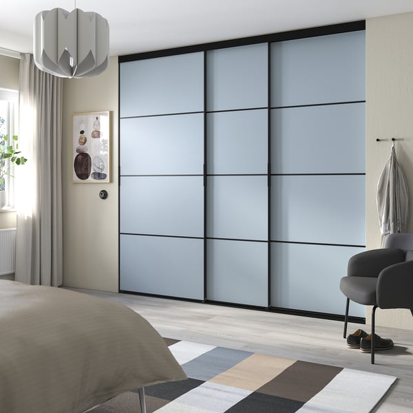 Moderne slaapkamer met grote grijze schuifdeuren, een grijs vloerkleed en een bed met grijs en beige beddengoed.