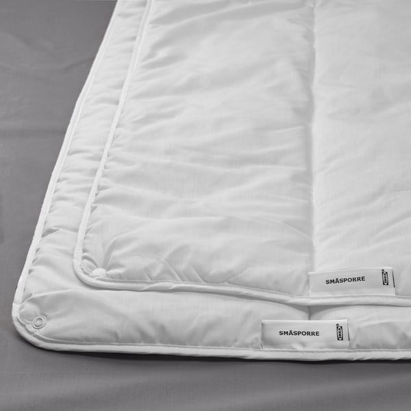 Wit katoen-polyester dekbed met gladde textuur, tweedelig ontwerp en merklabels.