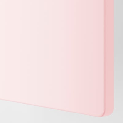 Een close-up van een pastelroze SMÅSTAD opbergdeuren gladde, afgeronde rand, die de hoogwaardige afwerking en het ontwerp laat zien.
