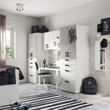 Moderne tienerslaapkamer met witte meubels van SMÅSTAD: bureau, kasten en kasten. Zwarte accenten, gestreept vloerkleed en decoratieve kunst aan de muur.
