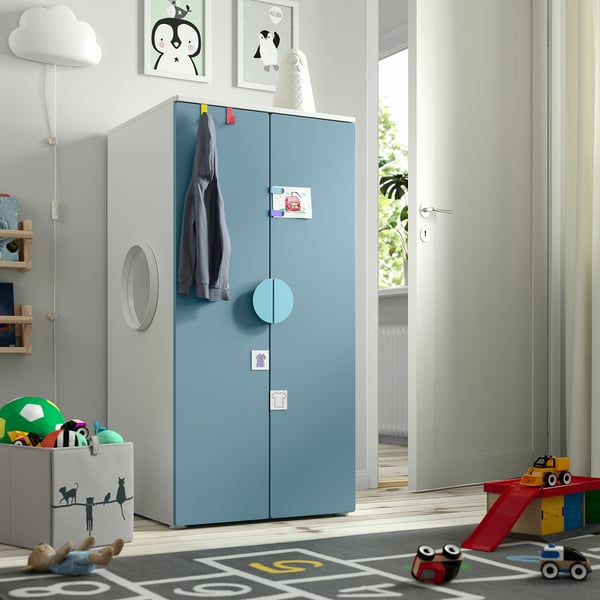 Blauw-witte SMÅSTAD kinderopberger met spiegel, plank en speelgoedkist in de speelkamer.