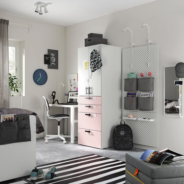 Moderne tienerslaapkamer met witte en pastelroze SMÅSTAD kledingkast, ophangbord, bureau en gestreept vloerkleed, grijstinten decoraties.