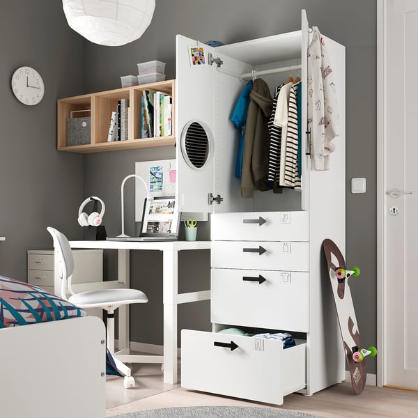 Moderne tienerslaapkamer met witte SMÅSTAD kledingkast en bureau, grijze muren, kleurrijke inrichting en skateboard.
