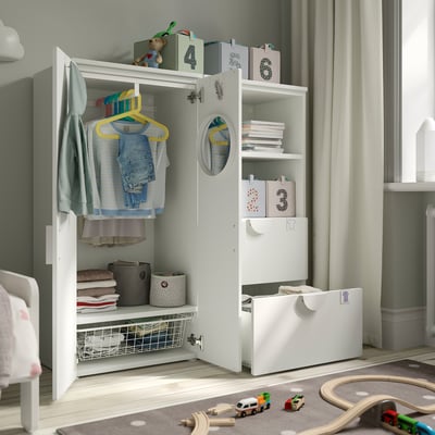 Childs garderobe met kleding, boeken en speelgoed. Planken, lades en hangers voor gemakkelijk bereik.