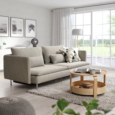 Moderne woonkamer met grijze SÖDERHAMN slaapbank, zwart-witte kussens, houten salontafel en grote ramen.