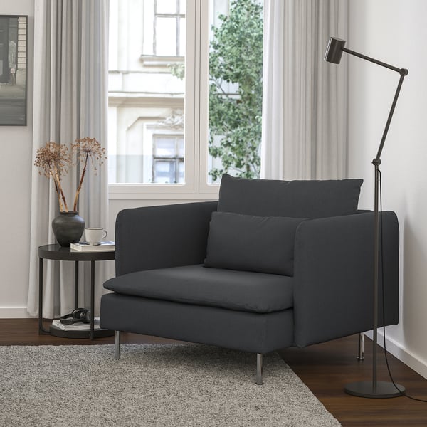 Moderne gezellige woonkamer: zwarte SÖDERHAMN fauteuil, strakke lamp, bijzettafel en groot raam.