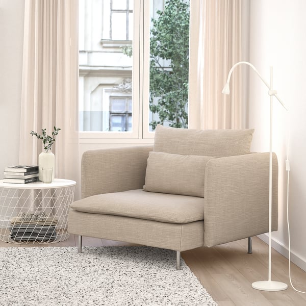SÖDERHAMN stoel, beige, katoenmix, lage en diepe zitting, bij groot raam, naast kleine tafel en staande lamp.