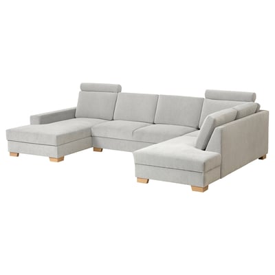 Deze afbeelding toont een grijze l-vormige SÖRVALLEN-bank met houten poten, met een minimalistisch scandinavisch design.